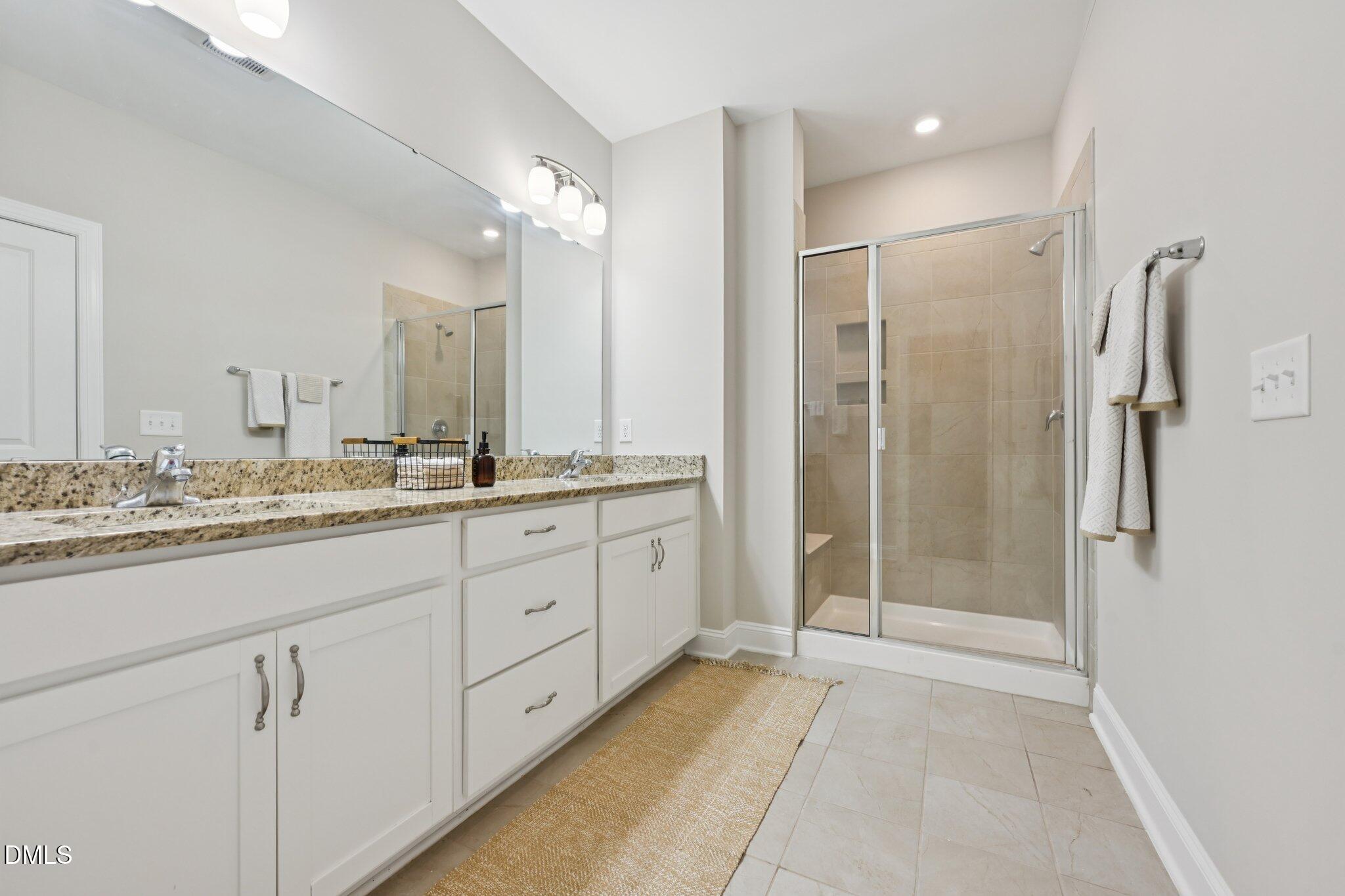 8405 Zinc Autumn Path Raleigh, NC 27615 - Photo 12 of 24 a bathroom with a granite countertop sink mirror and double