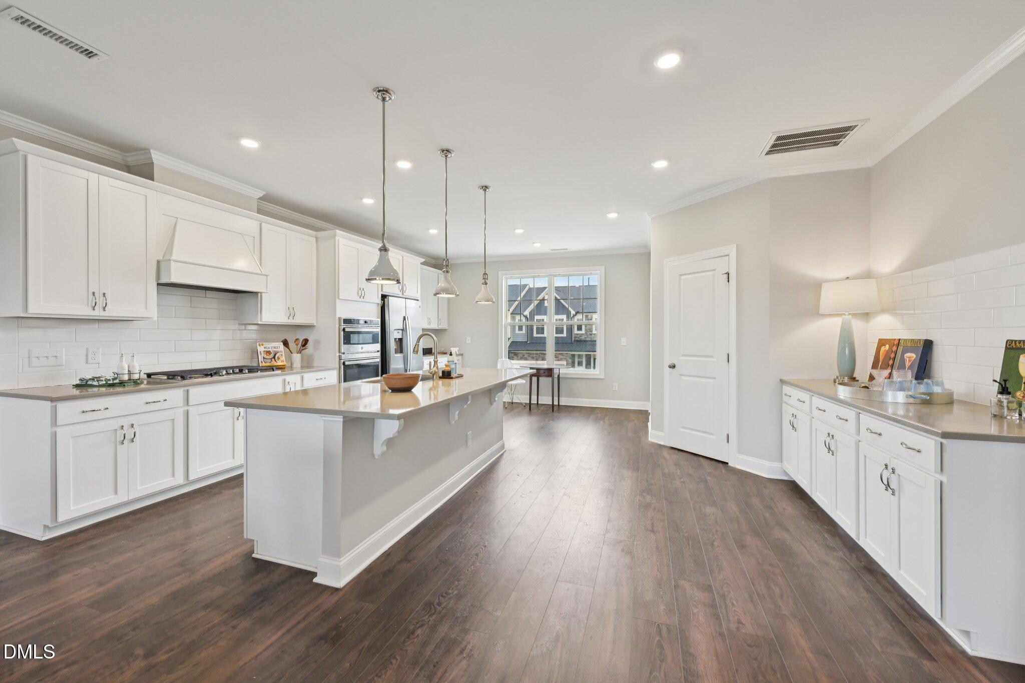 8405 Zinc Autumn Path Raleigh, NC 27615 - Photo 5 of 24 a large kitchen with granite countertop a large counter top a sink stainless steel appliances and cabinets