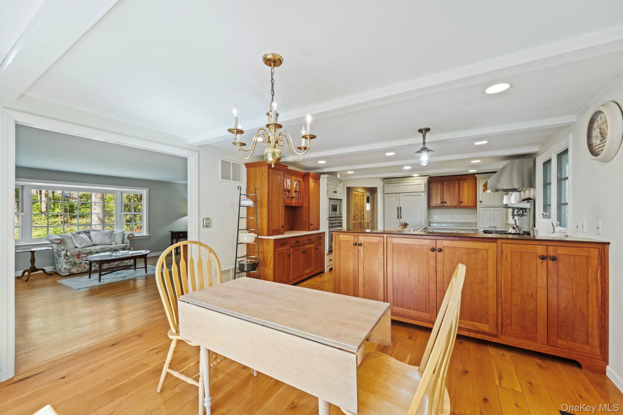 12 Harris Road Katonah, NY 10536 - Photo 7 of 38 a dining room with furniture a chandelier and wooden floor