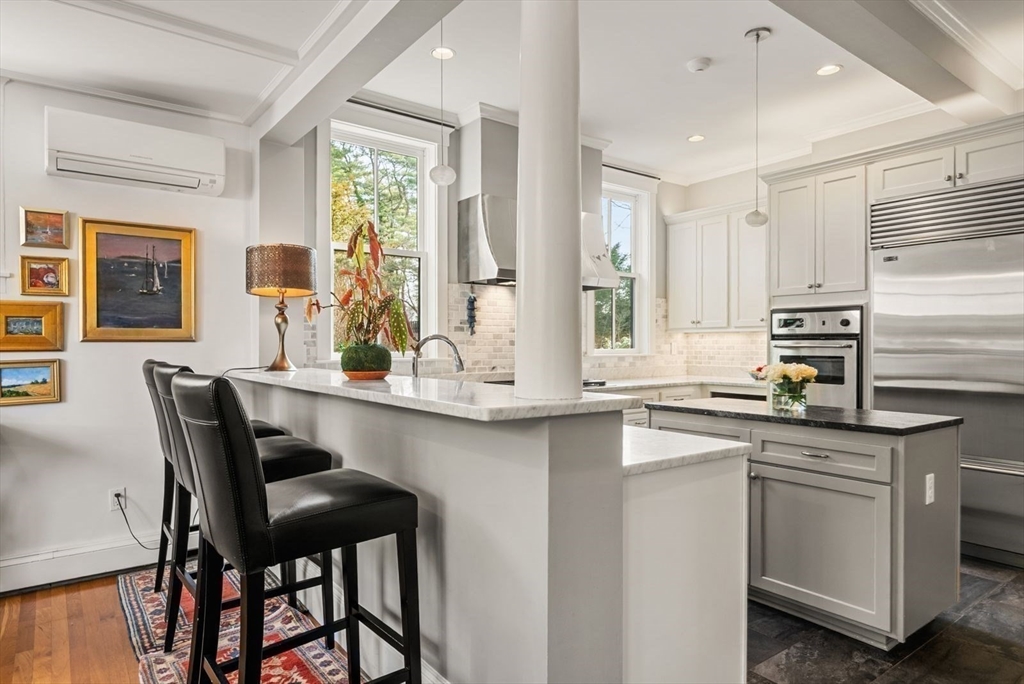 468 Summer Street Manchester, MA 01944 - Photo 8 of 36 a kitchen with stainless steel appliances granite countertop a table chairs in it and wooden floors