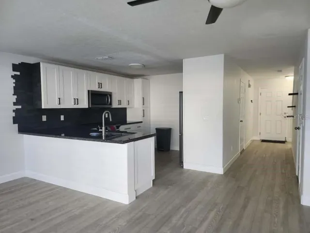 a kitchen with a refrigerator a stove top oven a sink and dishwasher with wooden floor