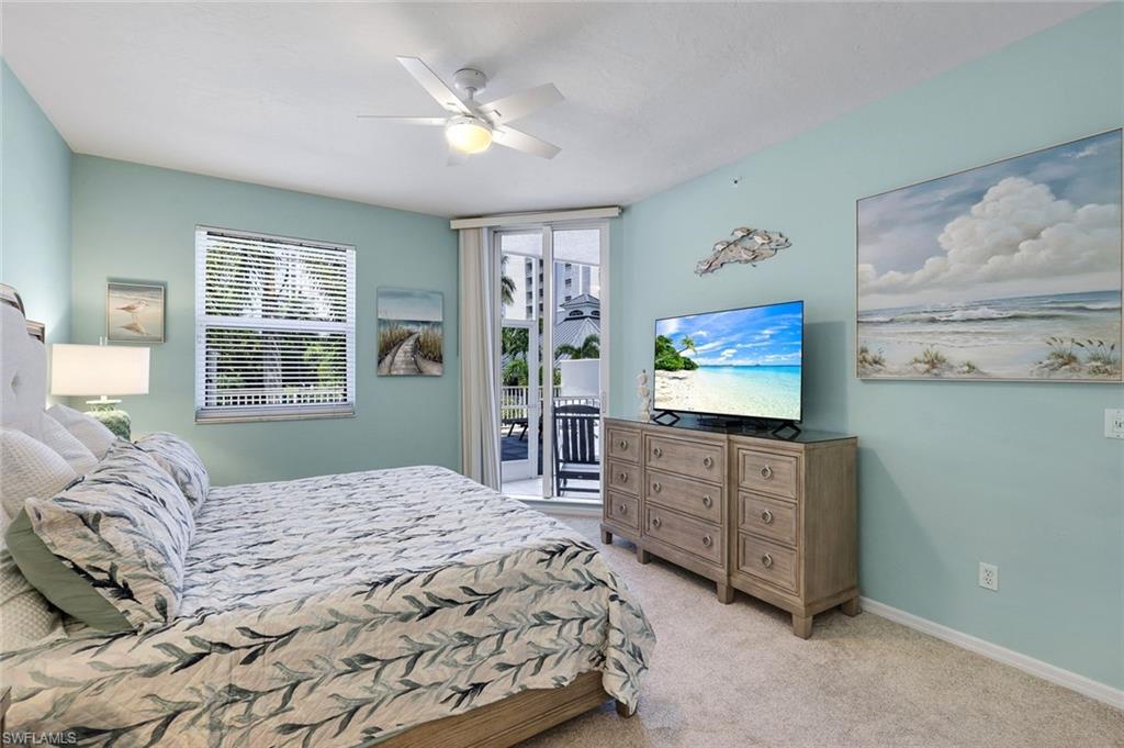 460 Launch Circle, Unit 202 Naples, FL 34108 - Photo 15 of 34 a bedroom with a bed and a flat screen tv