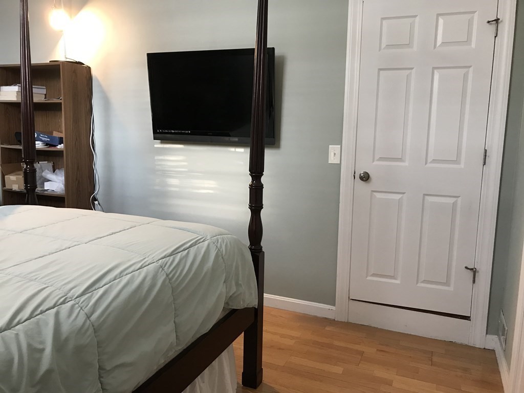 6 Braemore Road Natick, MA 01760 - Photo 18 of 27 a bedroom with a bed and a flat screen tv