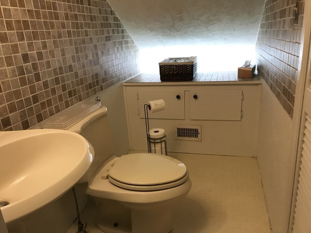 6 Braemore Road Natick, MA 01760 - Photo 24 of 27 a bathroom with a toilet a sink and mirror