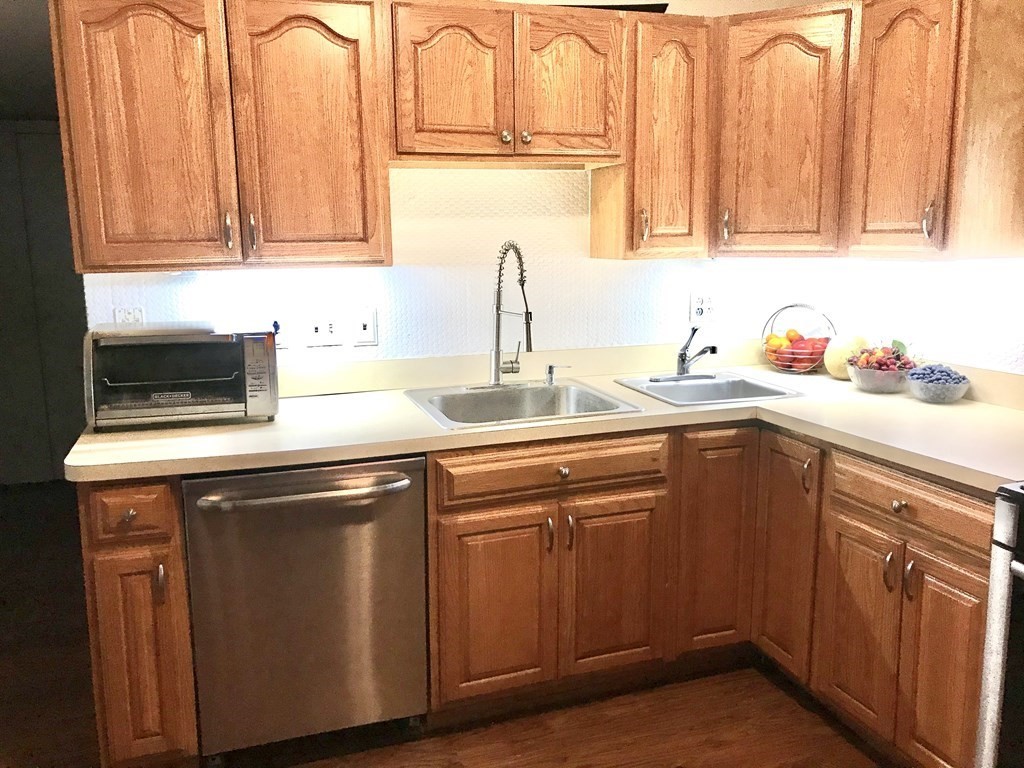 6 Braemore Road Natick, MA 01760 - Photo 3 of 27 a kitchen with stainless steel appliances granite countertop a sink stove and cabinets