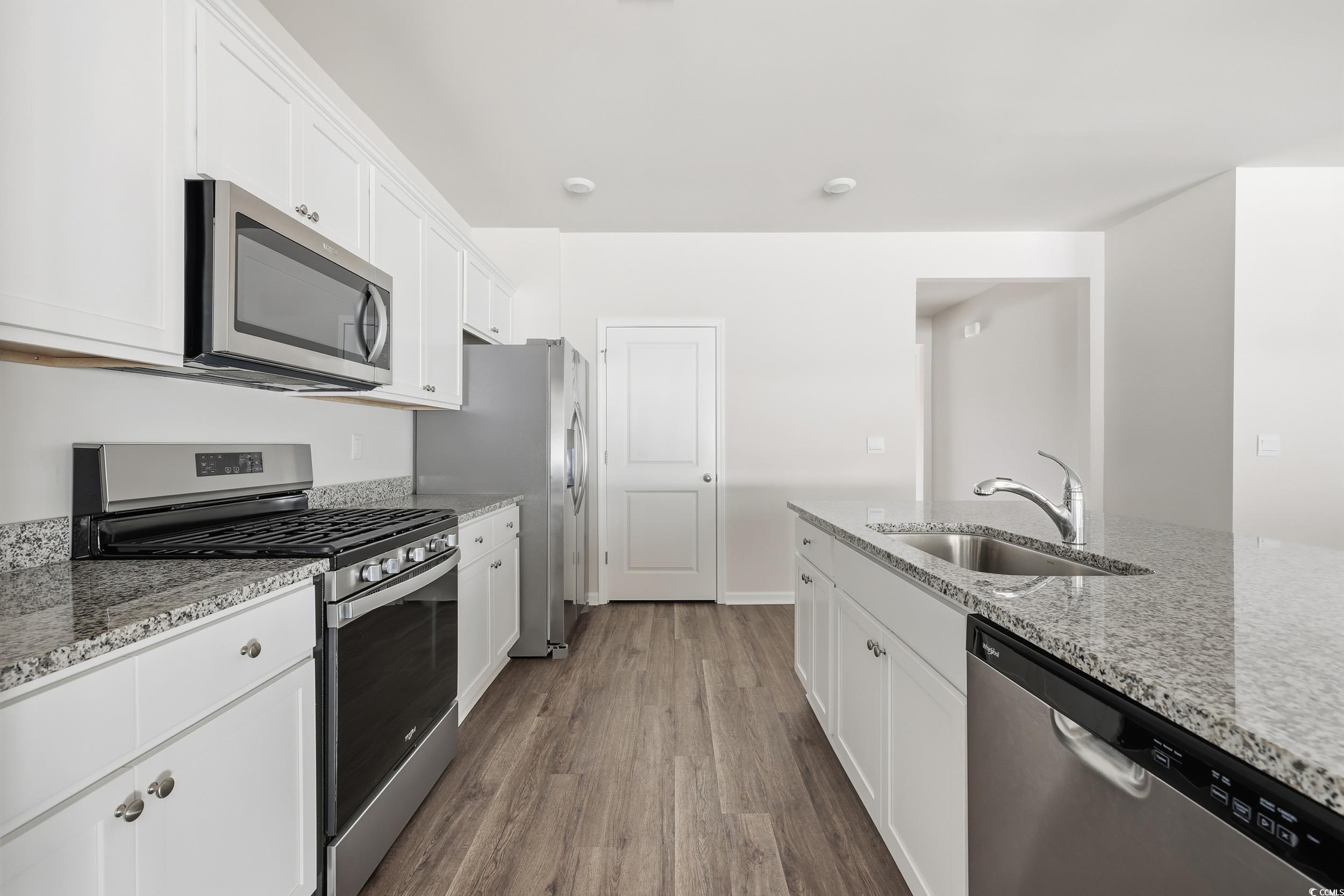 270 Columbus Street Conway, SC 29526 - Photo 2 of 38 Kitchen featuring appliances with stainless steel finishes, white cabinets, light stone countertops, and dark wood-style flooring