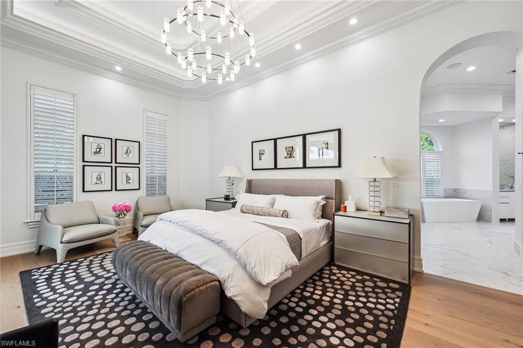 538 Riviera Drive Naples, FL 34103 - Photo 13 of 25 a bedroom with a bed and a chandelier