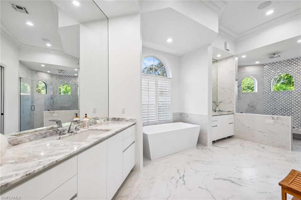 538 Riviera Drive Naples, FL 34103 - Photo 14 of 25 a spacious bathroom with a granite countertop tub sink and mirror