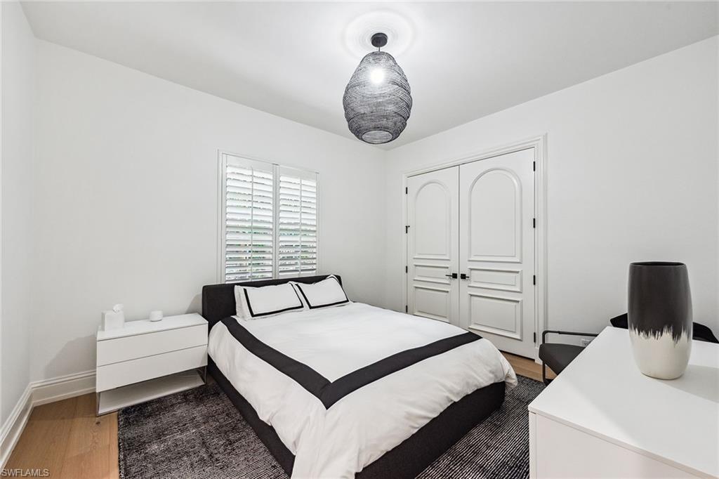 538 Riviera Drive Naples, FL 34103 - Photo 16 of 25 a bedroom with a bed and a chandelier