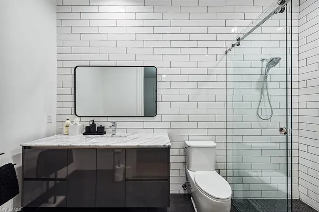 a bathroom with a toilet sink vanity and mirror