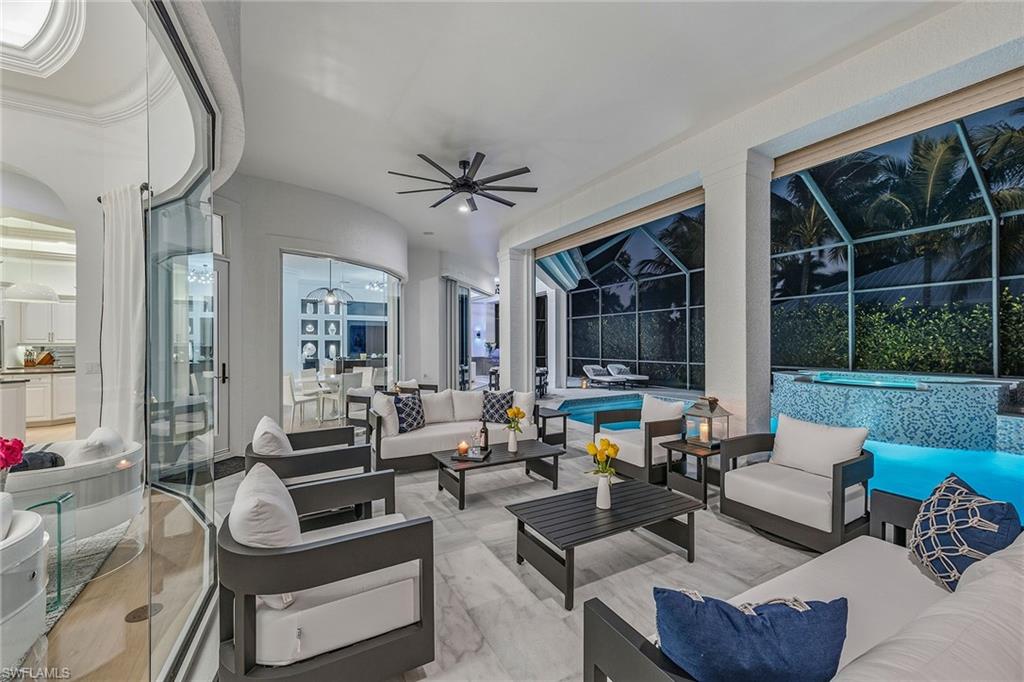 538 Riviera Drive Naples, FL 34103 - Photo 2 of 25 a living room with furniture a large window and a chandelier