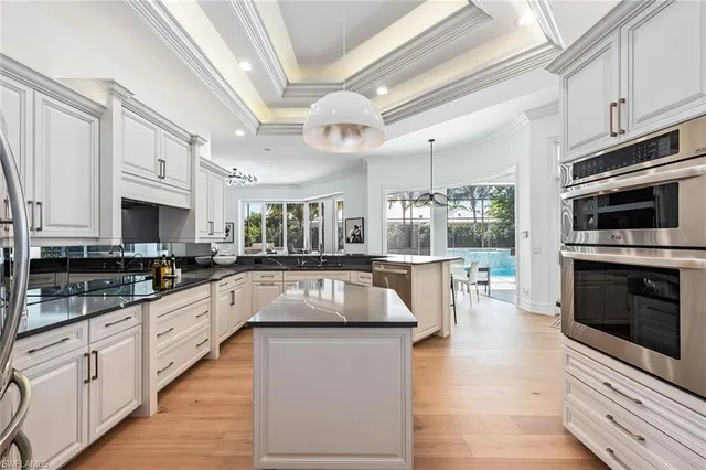 a kitchen with stainless steel appliances granite countertop a stove a sink and a microwave