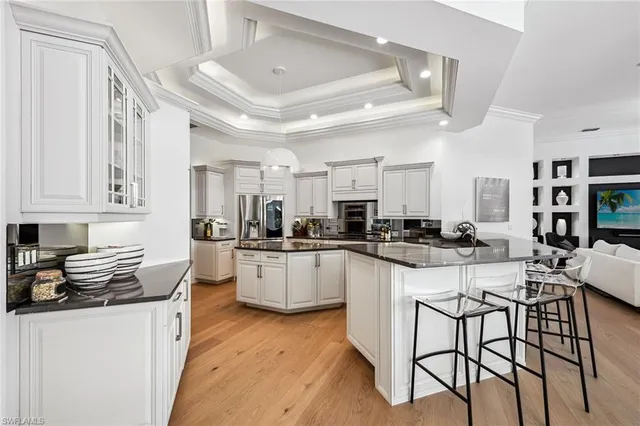 a kitchen with white cabinets and chairs