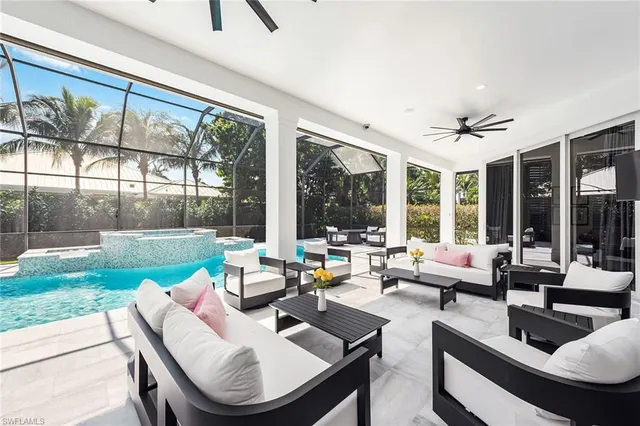a living room with patio furniture and a large window