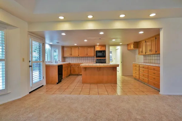 a kitchen with stainless steel appliances granite countertop a stove a sink and a refrigerator