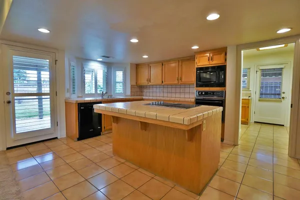 a kitchen with stainless steel appliances granite countertop a refrigerator a stove and a cabinets