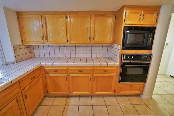 an empty room with windows and chandelier fan