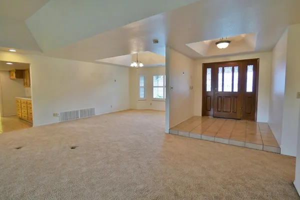 a dining room with furniture potted plants and a chandelier