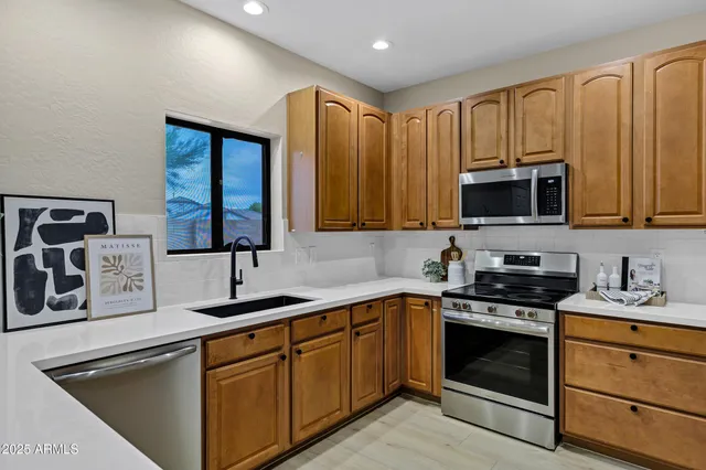 a kitchen with stainless steel appliances granite countertop a sink stove and microwave