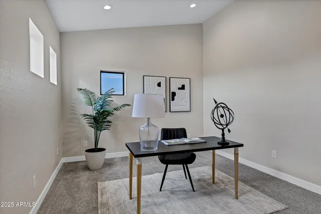 a workspace room with furniture and potted plant