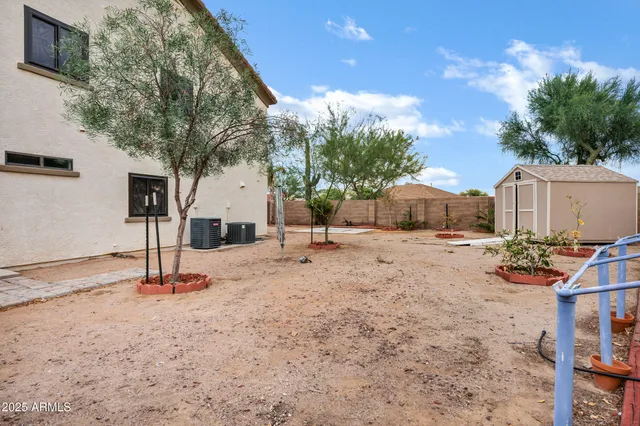 a backyard of a house with table and chairs