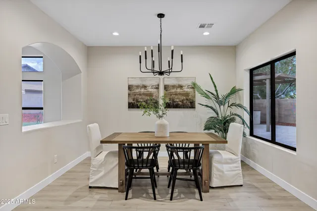 a dining room with furniture a chandelier and window