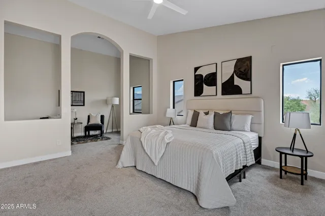 a spacious bedroom with a bed and a chandelier