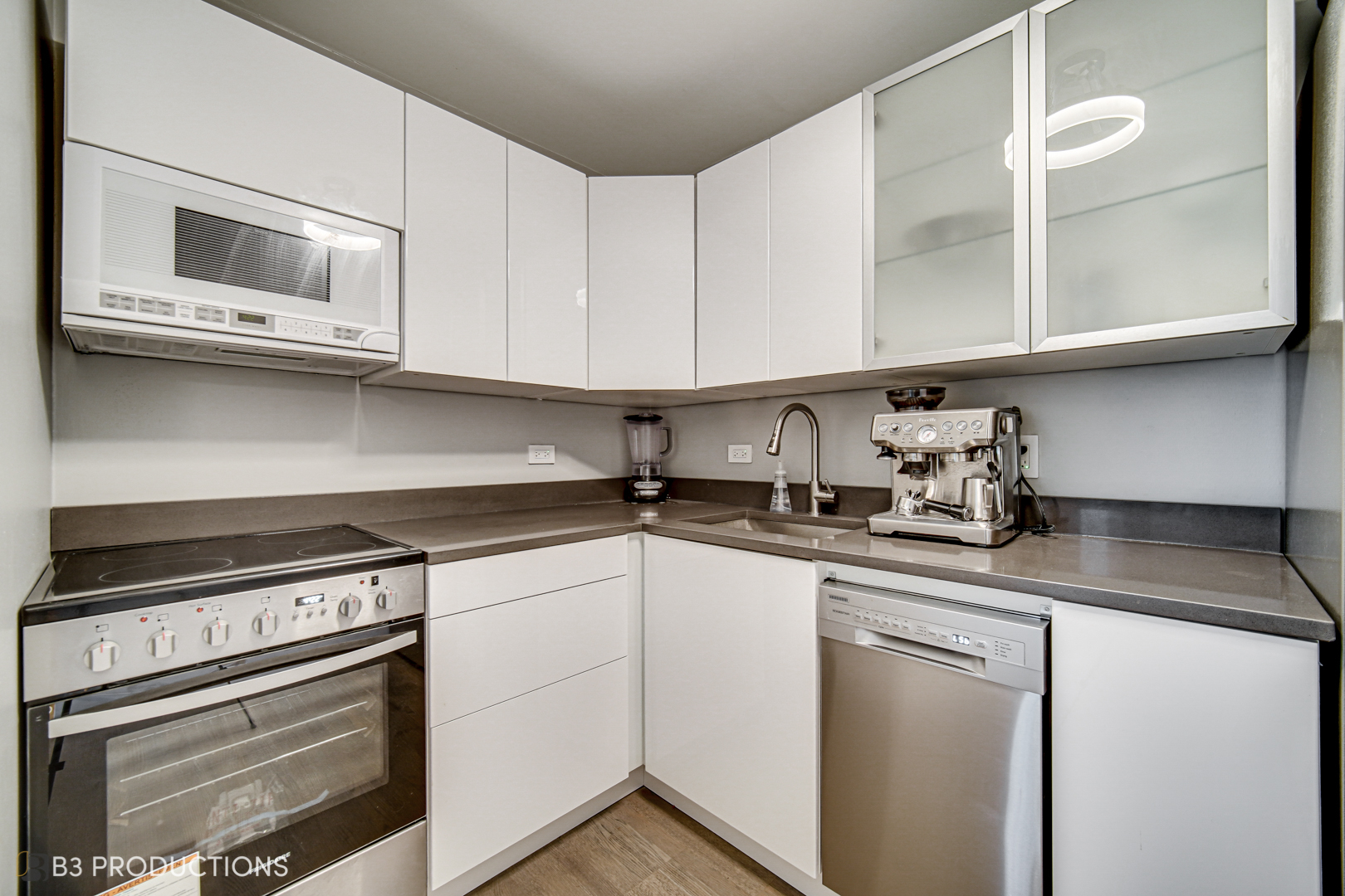 111 West Maple Street, Unit 3112 Chicago, IL 60610 - Photo 9 of 18 a kitchen with stainless steel appliances granite countertop a sink and a stove