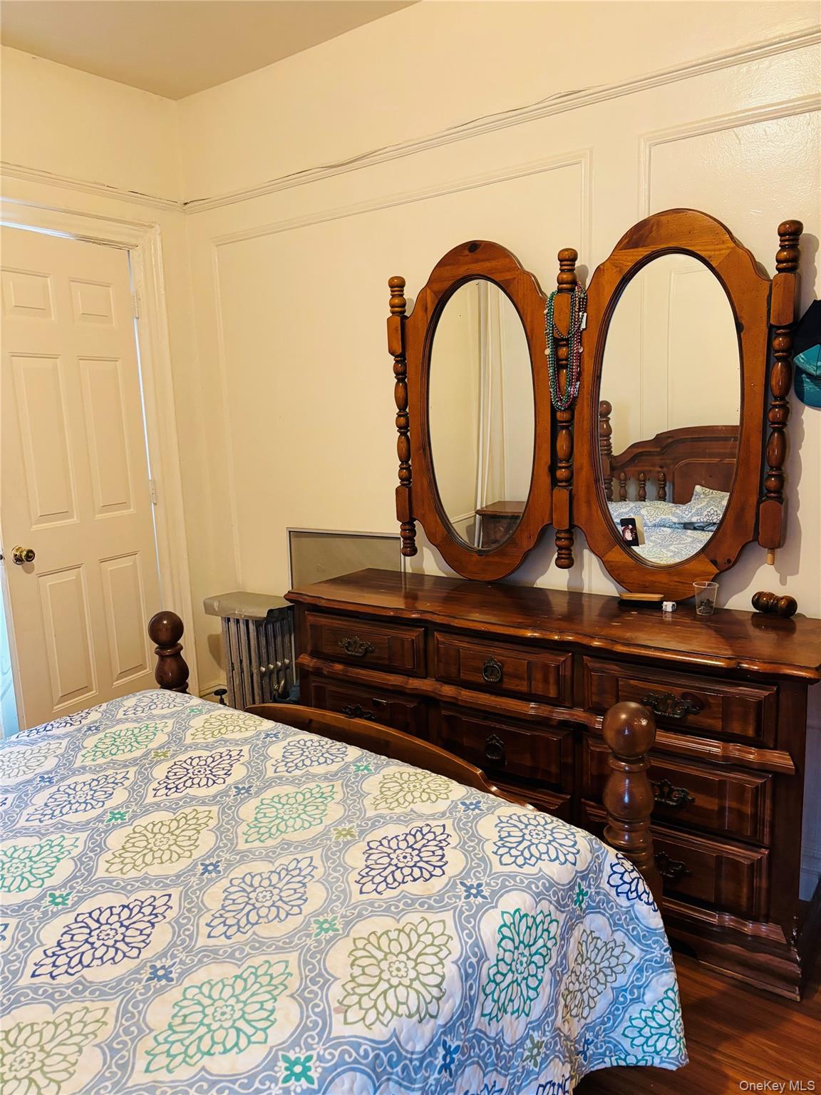715 Rosedale Avenue Bronx, NY 10473 - Photo 4 of 11 a bedroom with a bed a dresser and a wooden floor