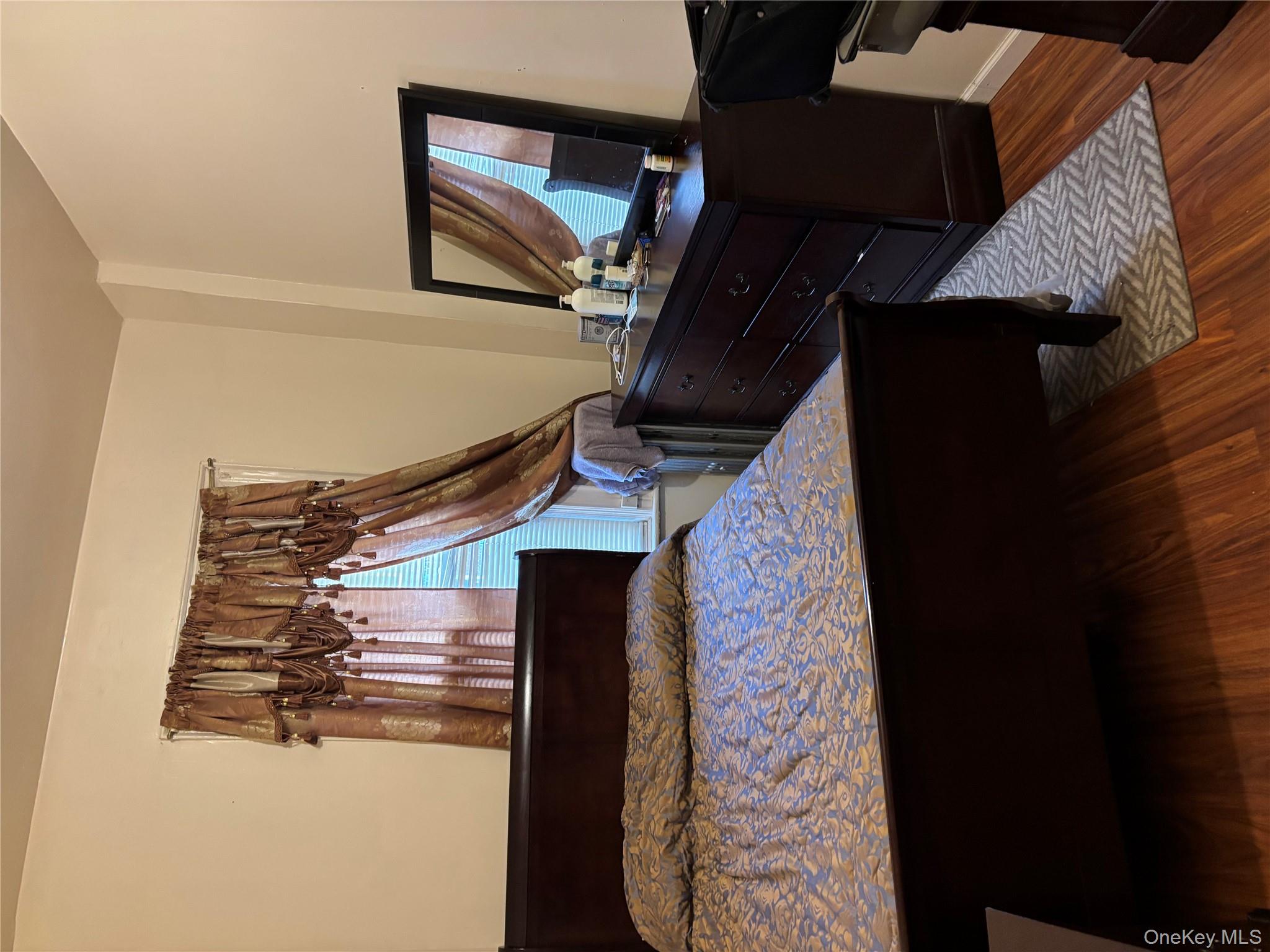 715 Rosedale Avenue Bronx, NY 10473 - Photo 9 of 11 a bed sitting in a bedroom next to a window with wooden floor