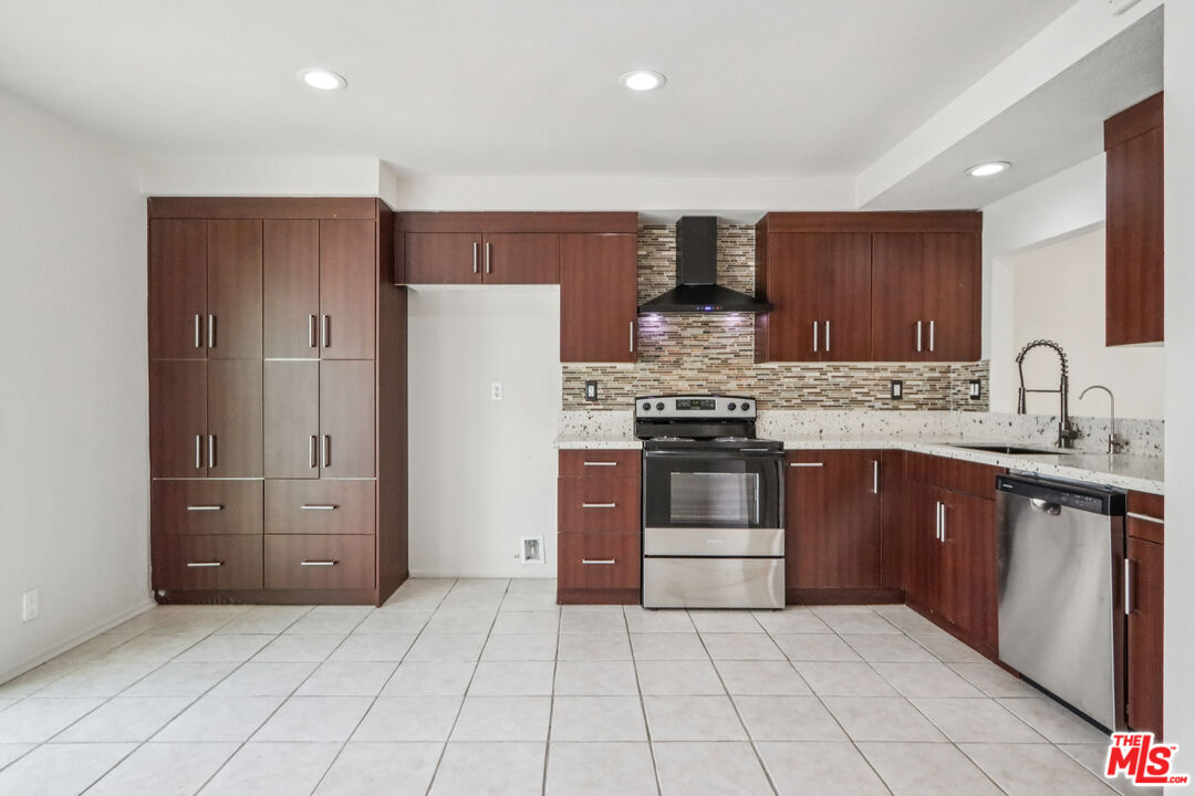 25885 Trabuco Road, Unit 226 Lake Forest, CA 92630 - Photo 13 of 23 a kitchen with stainless steel appliances granite countertop a refrigerator and a stove top oven
