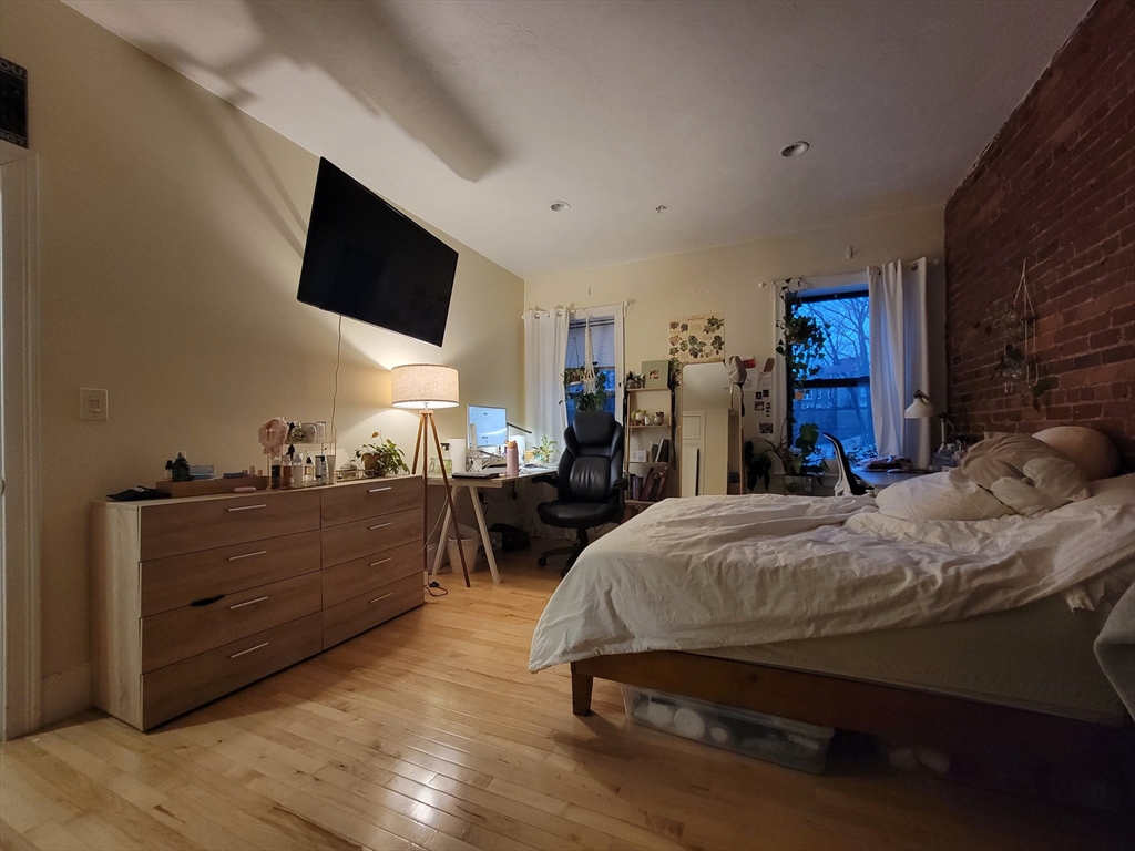 1203 Beacon Street, Unit 2 Brookline, MA 02446 - Photo 7 of 8 a bed room with furniture and a flat screen tv