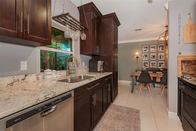 a kitchen with kitchen island granite countertop a sink stove and cabinets