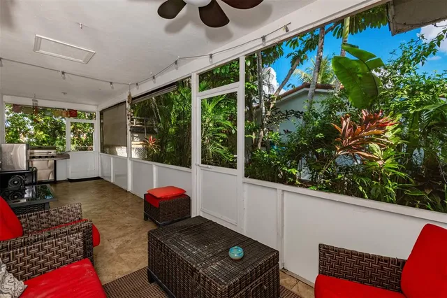 a backyard of a house with table and chairs under an umbrella