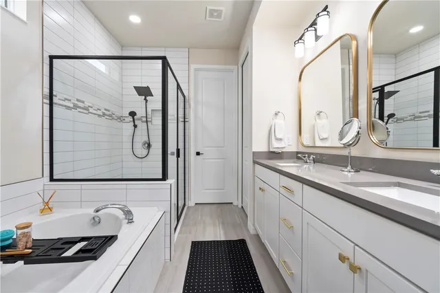 a bathroom with a double vanity sink a mirror and a shower