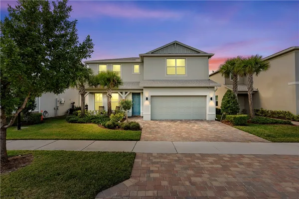 a front view of a house with a garden and garage