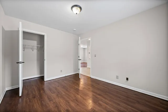 a view of an empty room with wooden floor