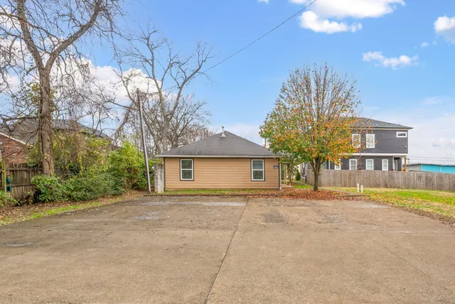 a front view of a house with a yard and trees