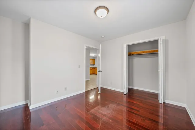 an empty room with wooden floor and closet