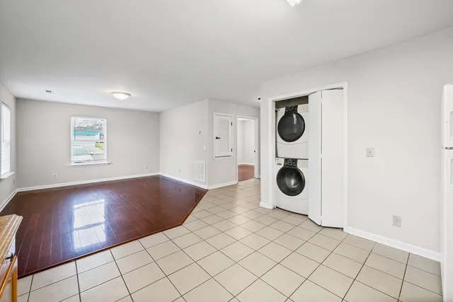 a view of kitchen and empty room with windows