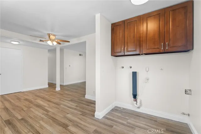 an empty room with wooden floor fireplace and windows