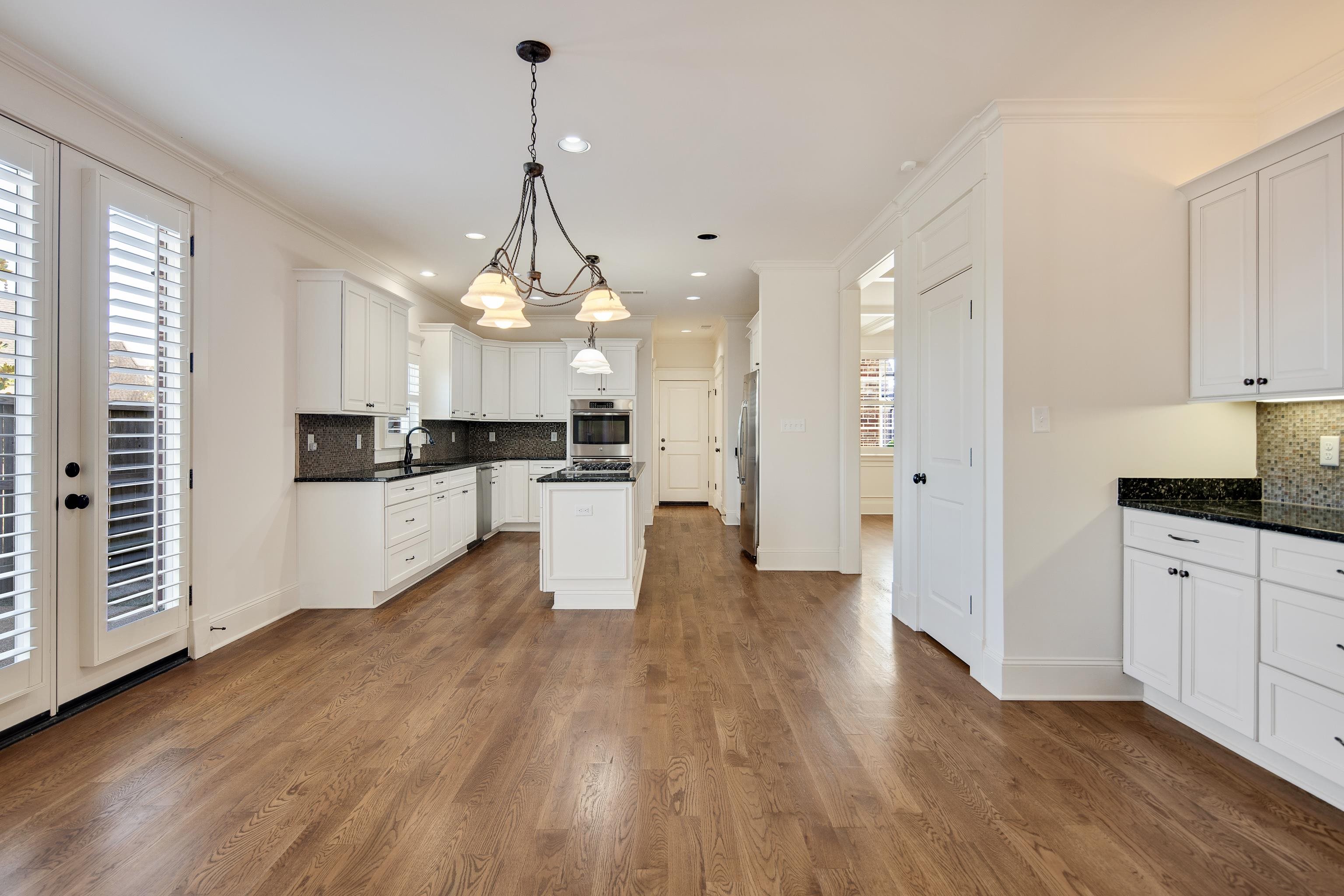 9110 Baynard Loop North Germantown, TN 38139 - Photo 13 of 40 a large kitchen with cabinets wooden floor and stainless steel appliances