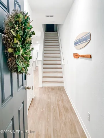 a view of a room with wooden floor and a potted plant