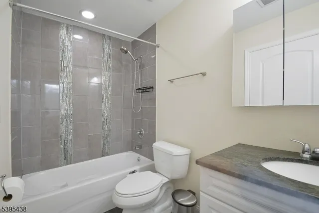 a bathroom with a granite countertop sink toilet a mirror and shower