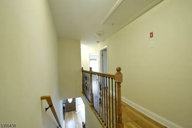 a view of an empty room with windows and chandelier fan