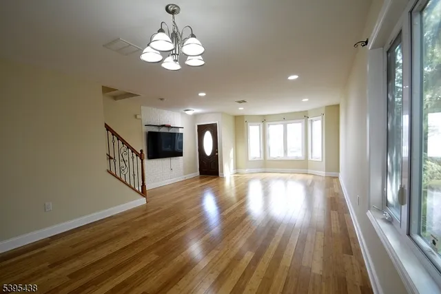 a dining room with wooden floor a chandelier a wooden table and chairs