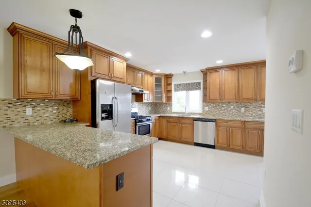 a kitchen with stainless steel appliances granite countertop a sink and a refrigerator