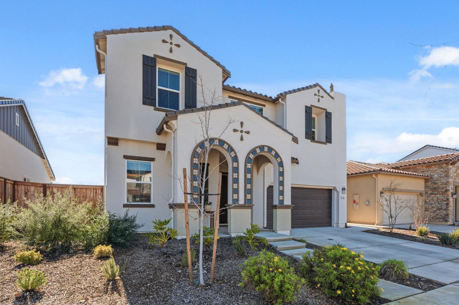 588 Overstone Avenue Madera, CA 93636 - Photo 3 of 65 a view of a white house with large windows and a small yard
