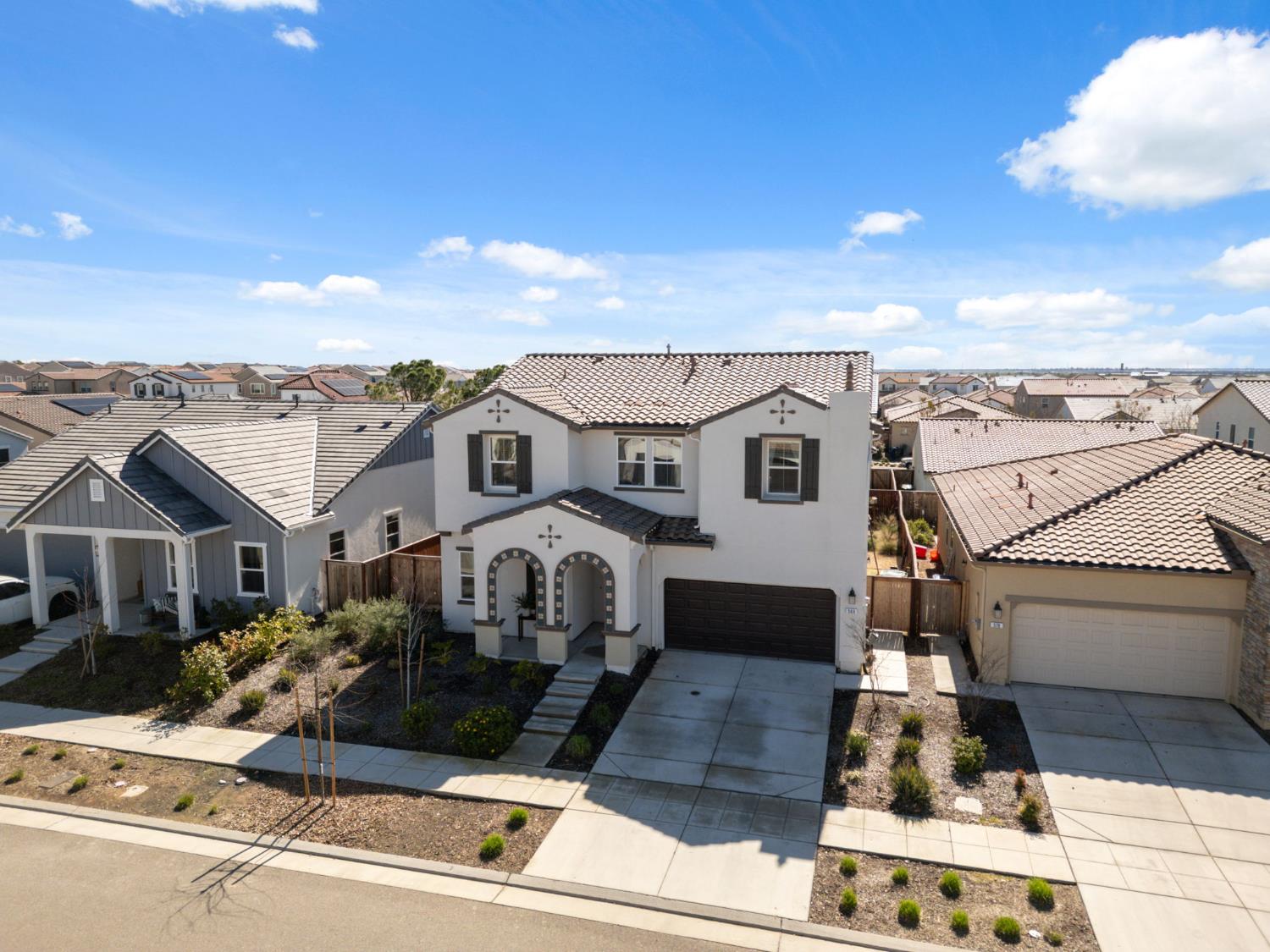 588 Overstone Avenue Madera, CA 93636 - Photo 43 of 65 a view of a white house with large windows and a table