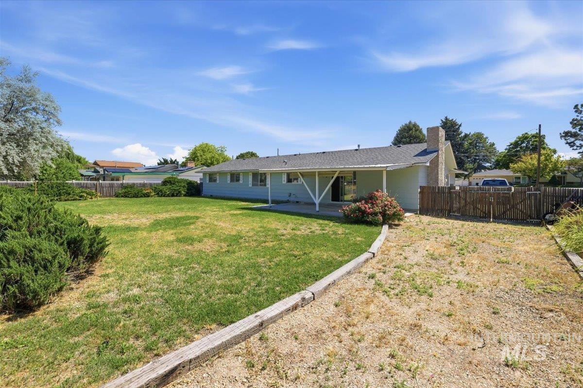 1311 North Middleton Road Nampa, ID 83651 - Photo 45 of 49 Expansive backyard with a covered patio, a blend of manicured lawn and natural landscaping, mature shrubs, and a partial privacy fence